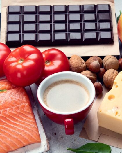Collection of dark chocolate, salmon, tomatoes, Swiss cheese, basil, whole nuts, appples and kiwi fruits to represent the best brain foods . recommended in the Five Finger Plan to a Healthy Brain, published by Robert Rose Inc.
